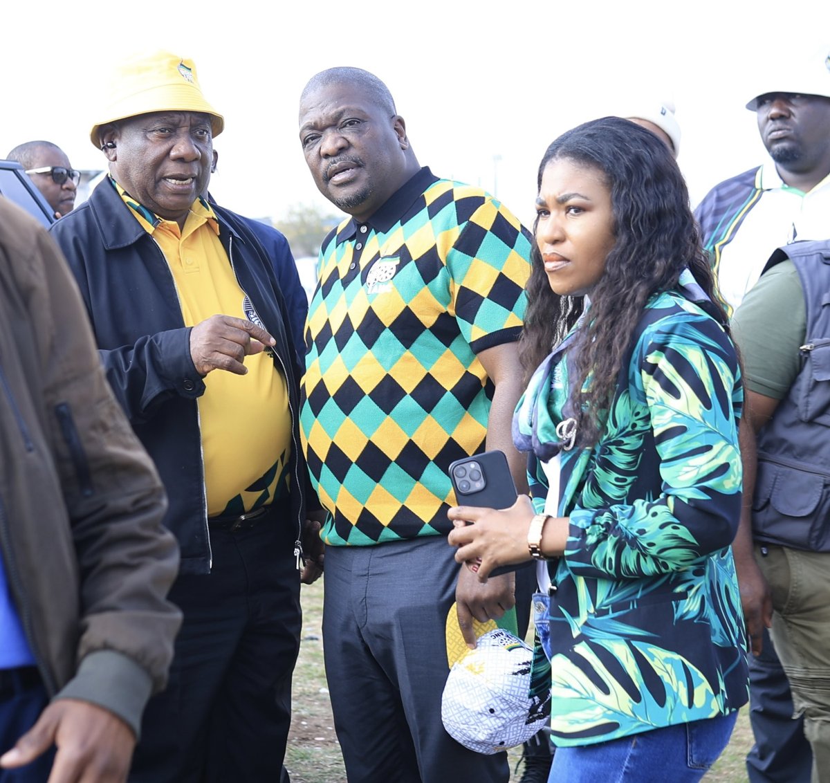 Cyril Ramaphosa standing with attendees at an outdoor campaign gathering.