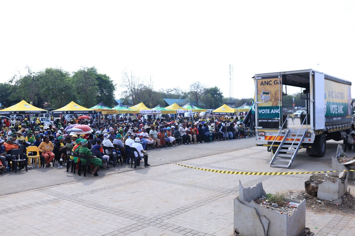Seated attendees, ANC tents and a campaign vehicle at the Ekurhuleni regional rally.