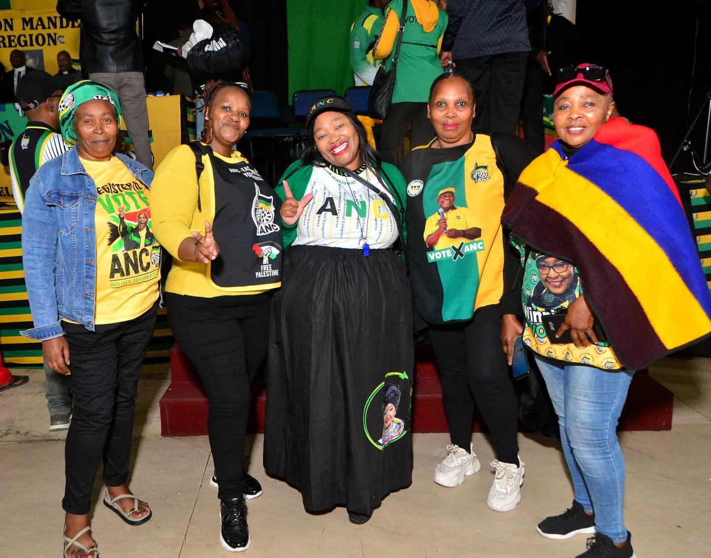 Five attendees pose together near the stage in ANC campaign clothing.