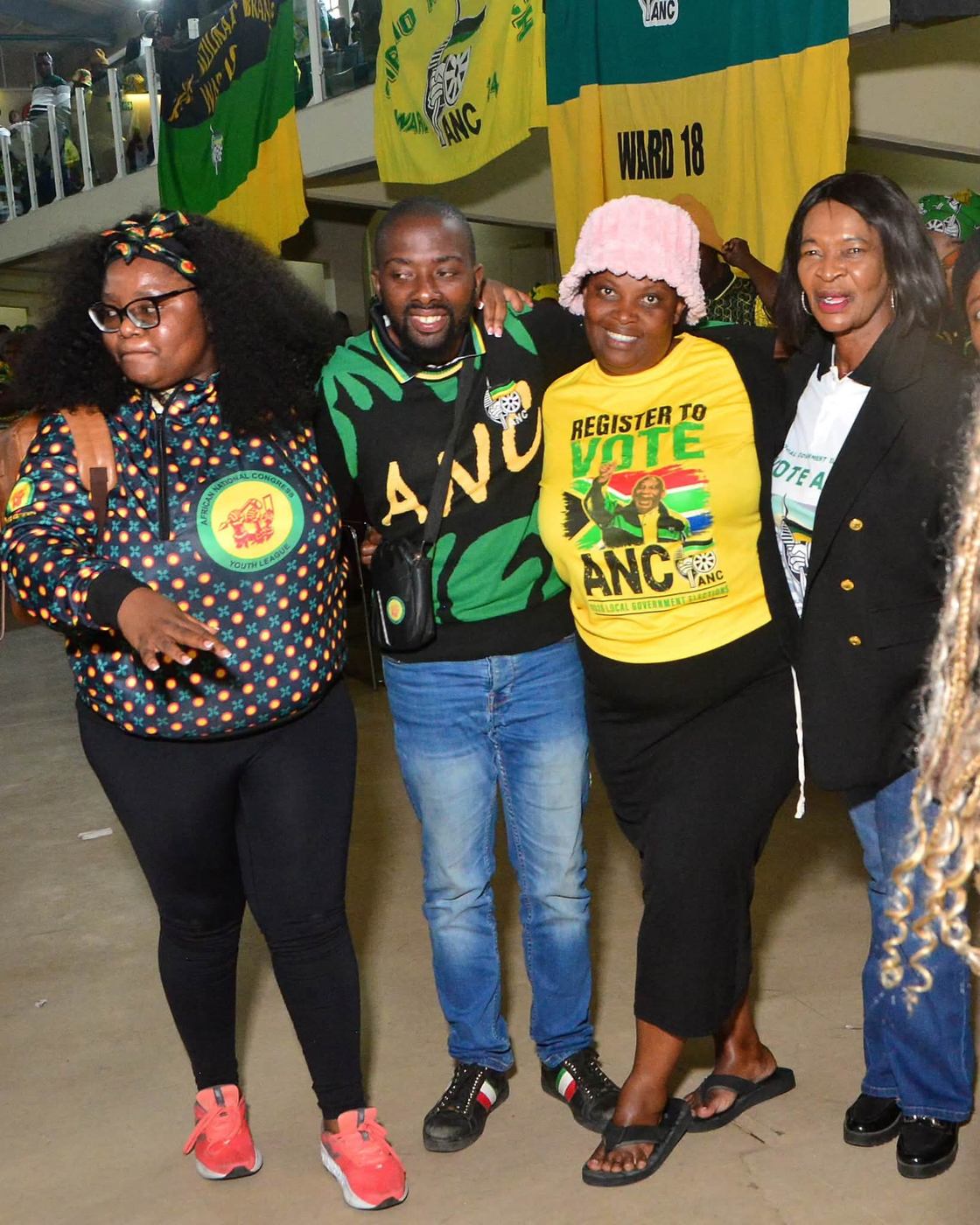 Four attendees pose beneath ANC banners, including a Ward 18 banner.
